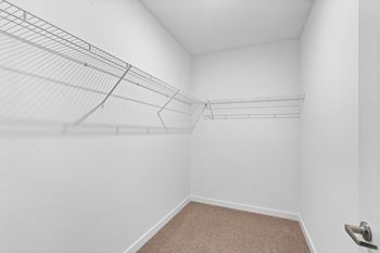 A white room with a carpeted floor and a metal rack on the wall.